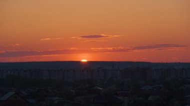 Güneş batarken akşam manzarası Uzak şehrin yüksek binalarının üzerinde gün batımında