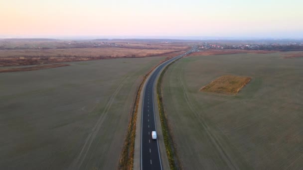 Luftaufnahme eines kleinen Lastwagens, der bei Sonnenuntergang auf der Autobahn Güter transportiert. Lieferverkehr und Logistikkonzept — Stockvideo