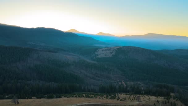 Bela paisagem panorâmica da montanha com picos nebulosos e vale nebuloso ao pôr do sol — Vídeo de Stock