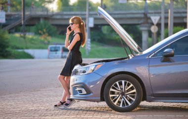 Kaputu açık bir şekilde arabasının yanında duran çaresiz kadın yardım için yol servisini arıyor. Genç bayan sürücünün aracıyla ilgili sorunları var