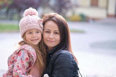 Genç ve güzel bir kadın, kızına sevgiyle sarılıyor. Aile ilişkileri kavramında mutluluk