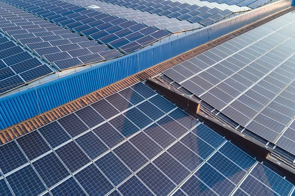 Techo del edificio vista aérea con filas de paneles fotovoltaicos solares azules para producir energía eléctrica ecológica limpia. Electricidad renovable con concepto de cero emisiones — Foto de Stock