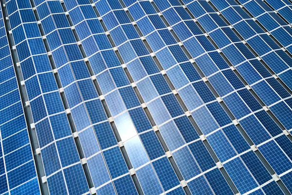 Aerial view of blue photovoltaic solar panels mounted on industrial building roof for producing green ecological electricity. Production of sustainable energy concept — Stock Photo, Image