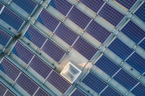 Sanayi binasının çatısına yeşil ekolojik elektrik üretmek için monte edilen mavi fotovoltaik güneş panellerinin hava görüntüsü. Sürdürülebilir enerji konsepti üretimi — Stok fotoğraf