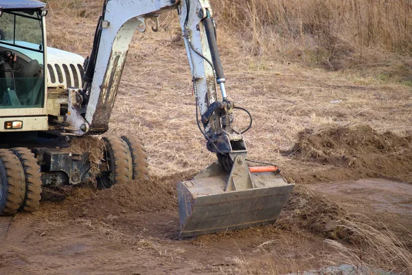 Earth moving tractor preparing place for future house foundation construction. Leveling soil for building new home — Stock Photo, Image