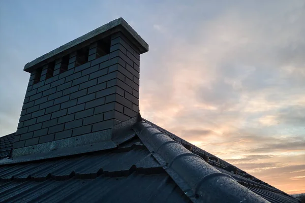 Cheminée sur le toit de la maison couverte de bardeaux métalliques en construction. Revêtement carrelé du bâtiment. Développement immobilier — Photo