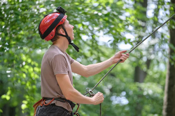 Mannen låser in sin partner klättrare med förseglingsanordning och rep. Klättrare handsman håller utrustning för bergsklättring säkerhet — Stockfoto