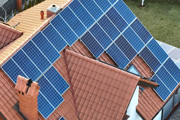 Casa residenziale con tetto coperto con pannelli fotovoltaici solari per la produzione di energia elettrica ecologica pulita in zona rurale suburbana. Concetto di casa autonoma — Foto Stock