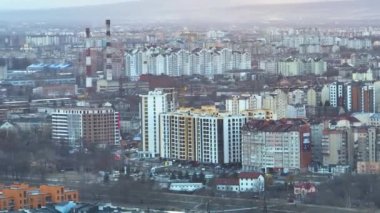 Yüksek binaların ve caddelerin şehrin yerleşim bölgesindeki trafiği gösteren hava manzarası.