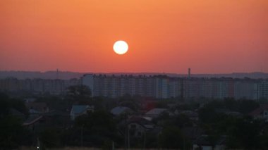 Güneş batarken akşam manzarası Uzak şehrin yüksek binalarının üzerinde gün batımında