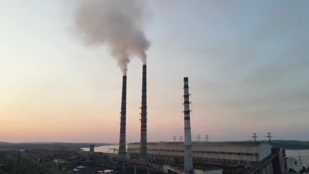 Vista aérea de las tuberías altas de la central eléctrica de carbón con humo negro que se mueve hacia arriba contaminando la atmósfera al atardecer. Producción de energía eléctrica con concepto de combustibles fósiles — Vídeos de Stock