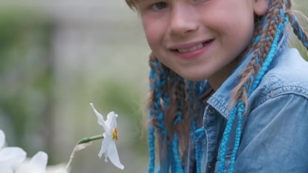 幸せな子供女の子楽しみます甘い香りの白いナルシスの花で夏の庭 — ストック動画