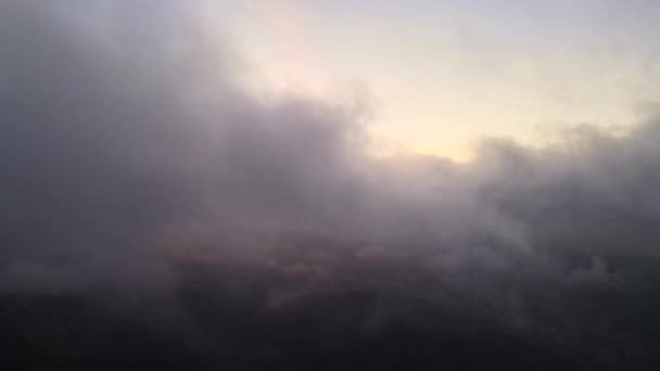 Luchtfoto van heldere mistige ochtend boven donkere piek met bergwoudbomen bij zonsopgang in de herfst. Prachtig landschap van wilde bossen bij dageraad — Stockvideo