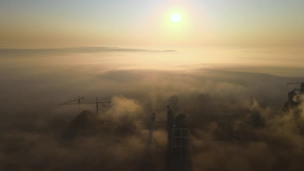 霧の夜に工業生産現場で高いコンクリート工場構造とタワークレーンとセメント工場の空中ビュー。生産とグローバル産業の概念 — ストック動画