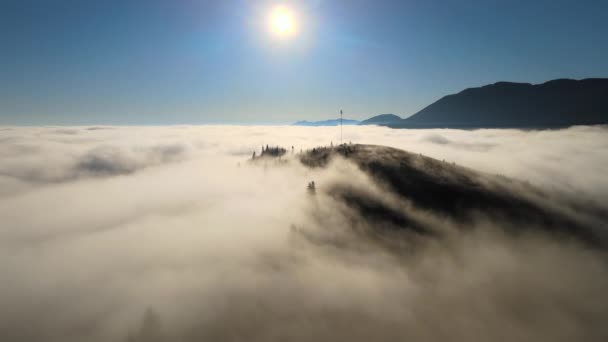 Aerial view of colorful sunrise over white dense fog with distant dark silhouettes of mountain hills on horizon — Stock Video