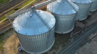 Uzun vadeli tahıl ve yağ tohumu depolamak için endüstriyel havalandırmalı siloların havadan görüntüsü. Tarım bölgesinde buğday kurutmak için metal asansör