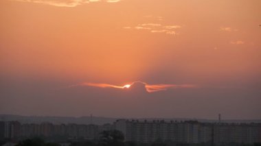 Güneş batarken akşam manzarası Uzak şehrin yüksek binalarının üzerinde gün batımında