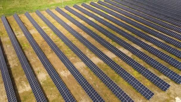 きれいな生態系の電気エネルギーを生成するための太陽光発電パネルの多くの行を持つ大規模な持続可能な電気発電所の空中ビュー。排出ゼロをコンセプトとした再生可能エネルギー — ストック動画