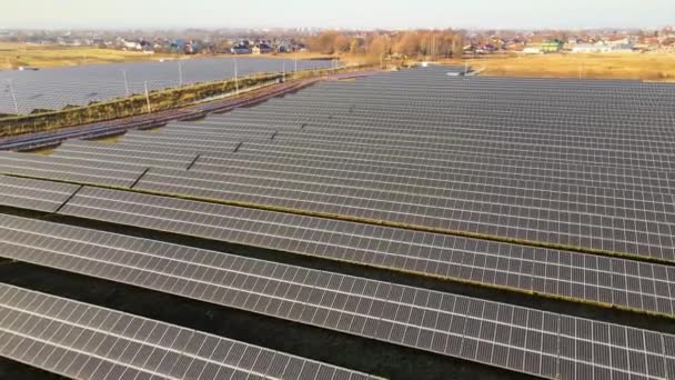 Temiz ekolojik elektrik enerjisi üretmek için sıra sıra güneş fotovoltaik panelleri olan sürdürülebilir büyük elektrik santralinin havadan görünüşü. Sıfır emisyon kavramı ile yenilenebilir elektrik — Stok video