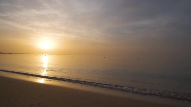 Côte de mer calme avec des vagues écrasantes sur la plage de sable au lever du soleil — Video