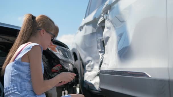 Sad female driver speaking on sellphone on street side calling for emergency service after car accident. Road safety and insurance concept — Stock Video