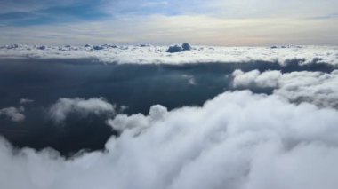 Dünya 'nın yüksek irtifasında, yağmur fırtınasından önce oluşan kabarık kümülüs bulutlarıyla kaplı uçak penceresinden hava görüntüsü
