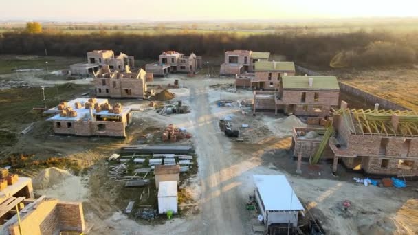 Letecký pohled na nové domy s cihlovými rámcovými zdmi ve výstavbě ve venkovské příměstské oblasti. Rozvoj nemovitostí v moderních předměstích — Stock video