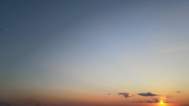 Strahlend bunter Abendhimmel mit Sonnenstrahlen und Vogelscharen, die gegen die untergehende Sonne fliegen — Stockvideo