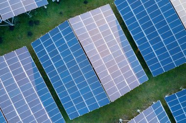 Temiz ekolojik elektrik enerjisi üretmek için sıra sıra güneş fotovoltaik panelleri olan sürdürülebilir büyük elektrik santralinin havadan görünüşü. Sıfır emisyon kavramı ile yenilenebilir elektrik.