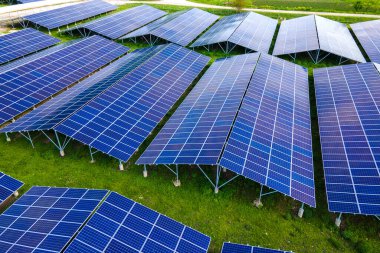 Temiz ekolojik elektrik enerjisi üretmek için sıra sıra güneş fotovoltaik panelleri olan sürdürülebilir büyük elektrik santralinin havadan görünüşü. Sıfır emisyon kavramı ile yenilenebilir elektrik