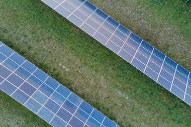 Temiz ekolojik elektrik enerjisi üretmek için sıra sıra güneş fotovoltaik panelleri olan sürdürülebilir büyük elektrik santralinin havadan görünüşü. Sıfır emisyon kavramı ile yenilenebilir elektrik
