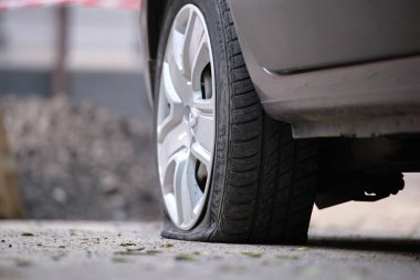 Yol kenarında lastiği patlamış bir araba.