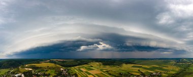 Kırsal alan üzerindeki fırtına sırasında gökyüzünde oluşan kara bulutların manzarası