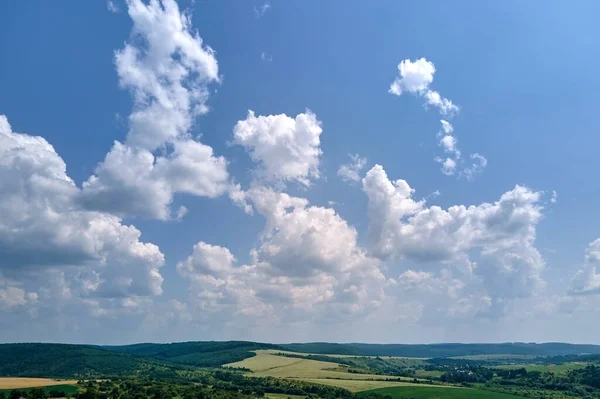 Letecký výhled na jasnou modrou oblohu nad zeleně obdělávanými zemědělskými poli s rostoucí úrodou a vzdálenými lesy za jasného letního dne — Stock fotografie
