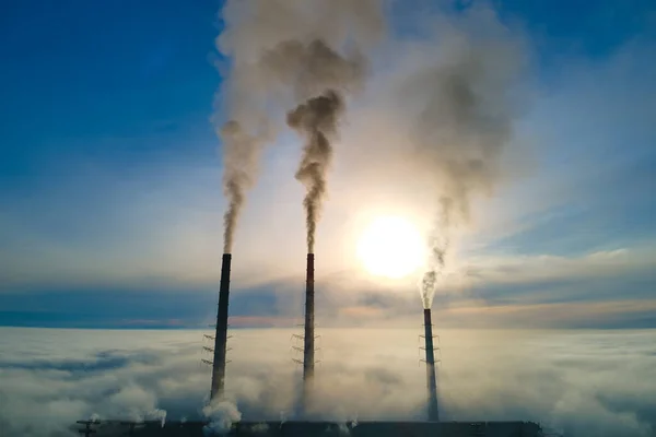 Uitzicht vanuit de lucht op hoge pijpen van kolencentrales met zwarte rook die bij zonsondergang de vervuilende atmosfeer opgaat — Stockfoto