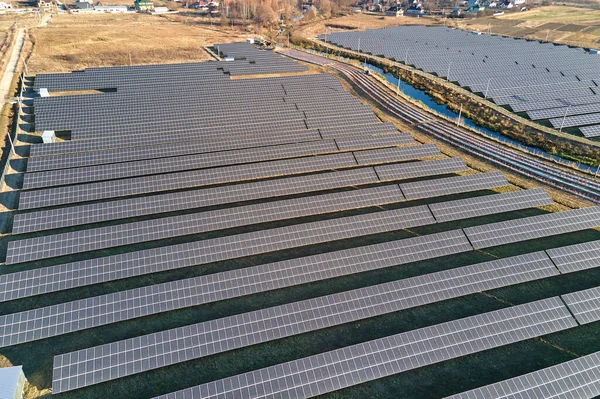 Luftaufnahme eines großen nachhaltigen Elektrizitätswerks mit Reihen von Photovoltaikmodulen zur Erzeugung sauberer ökologischer Elektrizität. Erneuerbarer Strom mit Null-Emissions-Konzept — Stockfoto