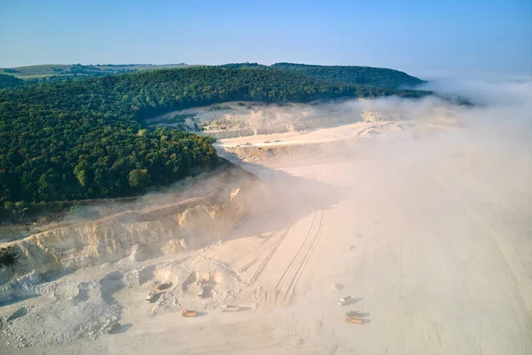 Aerial view of open pit mining of limestone materials for construction industry with excavators and dump trucks — Stock Photo, Image