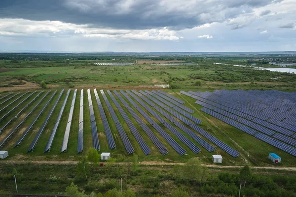 Widok z powietrza elektrowni słonecznej na zielone pole. Gospodarstwo elektryczne z panelami do produkcji czystej energii ekologicznej — Zdjęcie stockowe