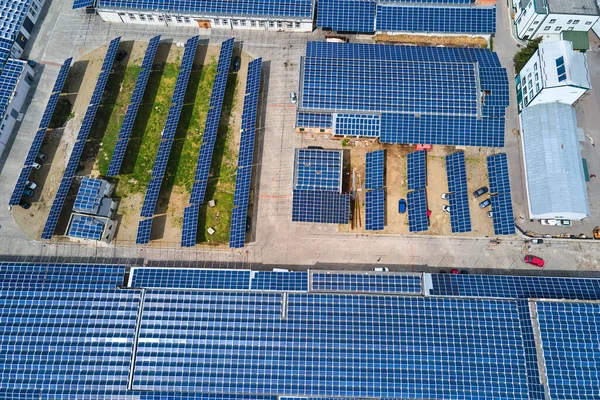 Letecký pohled na solární elektrárnu s modrými fotovoltaickými panely namontovanými na střeše průmyslové budovy pro výrobu zelené ekologické elektřiny. Výroba koncepce udržitelné energie — Stock fotografie