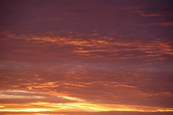 Jasná barevná obloha západu slunce s paprsky zapadajícího slunce a jasnými tmavými mraky — Stock fotografie