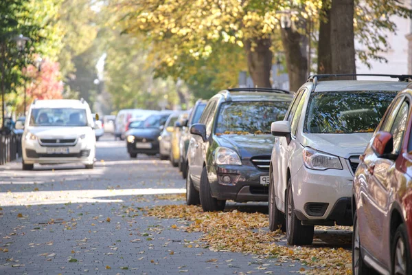 Городское движение с большим количеством машин, припаркованных в очереди на обочине — стоковое фото