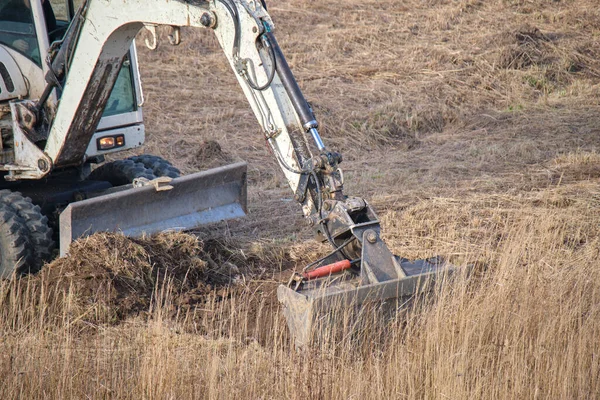 Terra trator em movimento lugar de preparação para a construção futura fundação da casa. Nivelamento do solo para a construção de nova casa — Fotografia de Stock