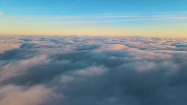 Flygfoto ovanifrån på hög höjd av täta fluffiga cumulusmoln som flyger på kvällen. Fantastisk solnedgång från flygplansfönstrets synvinkel — Stockvideo