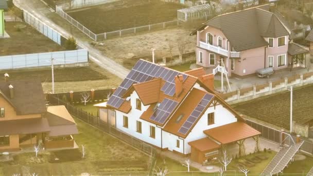 Ιδιωτική στέγη κατοικίας που καλύπτεται με ηλιακούς φωτοβολταϊκούς συλλέκτες για την παραγωγή καθαρής οικολογικής ηλεκτρικής ενέργειας στην προαστιακή αγροτική περιοχή της πόλης. Έννοια της αυτόνομης κατοικίας — Αρχείο Βίντεο