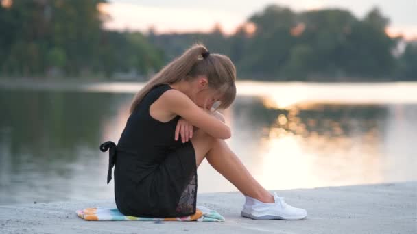 Mulher jovem triste sentado sozinho ao ar livre chorando amargamente. Conceito de depressão e emoções — Vídeo de Stock
