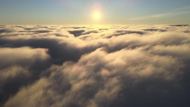Vedere aeriană de sus, la altitudine mare, a norilor umflați și umflați care zboară seara. Apus de soare uimitor din punctul de vedere al ferestrei avionului — Videoclip de stoc