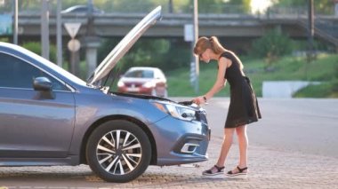 Kaputu açık halde arabasının yanında duran çaresiz bir kadın cep telefonundan yardım için yol servisini arıyor. Genç bayan sürücünün aracıyla ilgili sorunları var