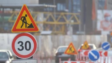 Yol çalışmaları trafik işaretlerini uyardı. Şehir caddesinde inşaat çalışması ve yavaş hareket eden arabalar.