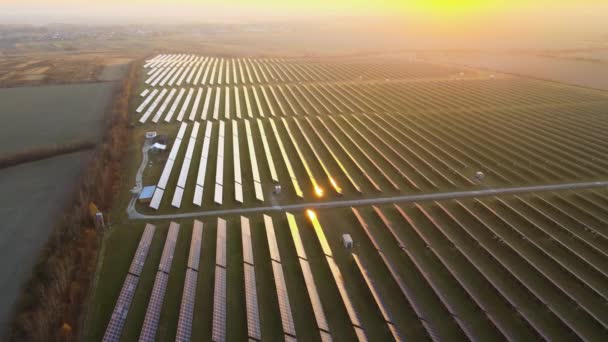 Вид с воздуха на большую устойчивую электростанцию с рядами солнечных фотоэлектрических панелей для производства чистой электрической энергии в вечернее время. Концепция возобновляемой электроэнергии с нулевой эмиссией — стоковое видео