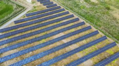 Yeşil alandaki güneş enerjisi santralinin havadan görüntüsü. Temiz ekolojik enerji üretmek için panelleri olan elektrik çiftliği